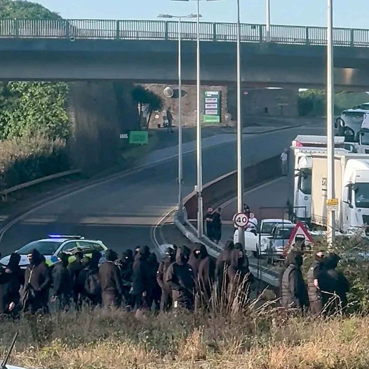 Black-clad protesters in balaclavas block road at port of Dover in Kent